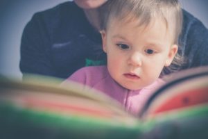 parent and baby looking at book