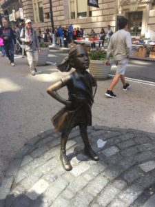 Bronze statue of a young girl posing as a super hero
